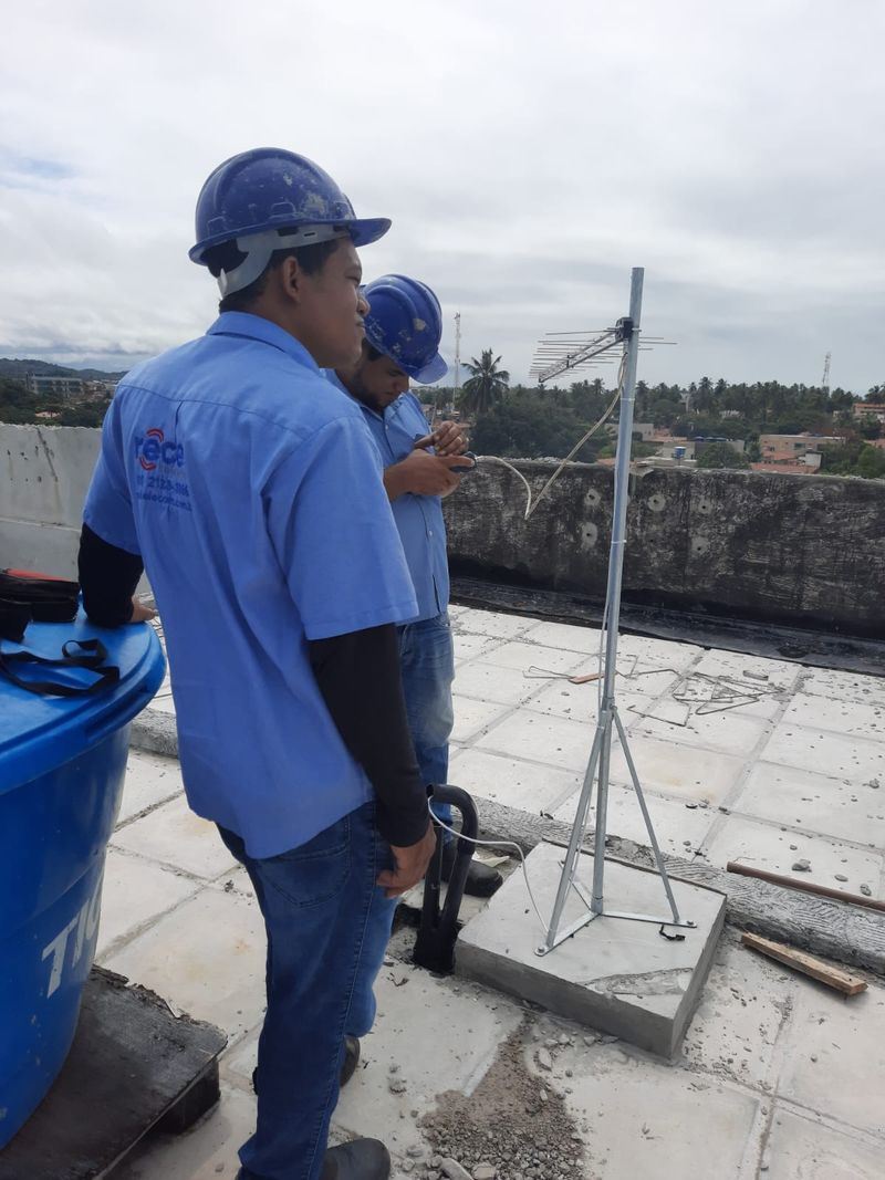 Técnicos da Recel ajustando antena coletiva na cobertura