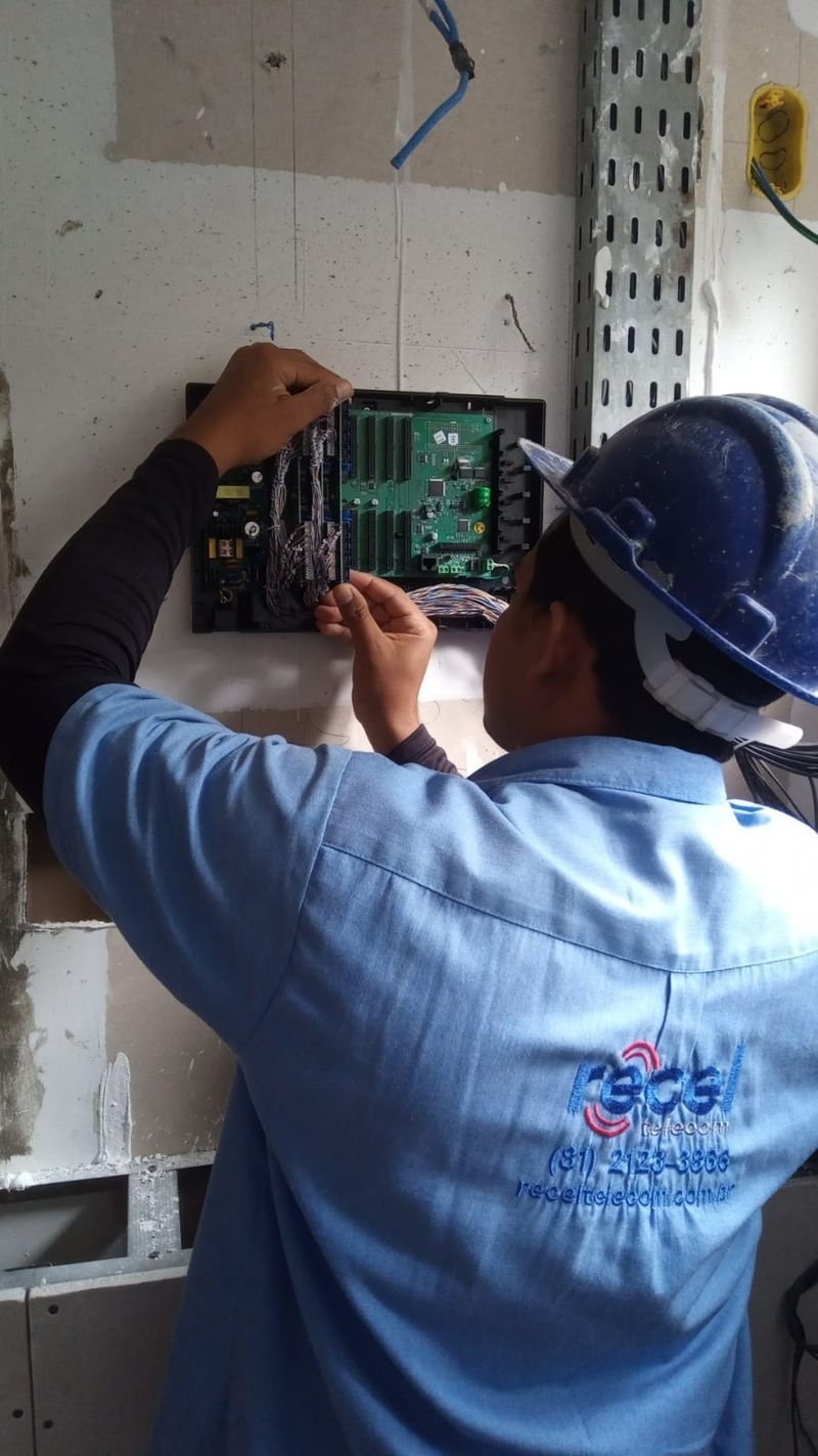 Técnico instalando central de interfonia