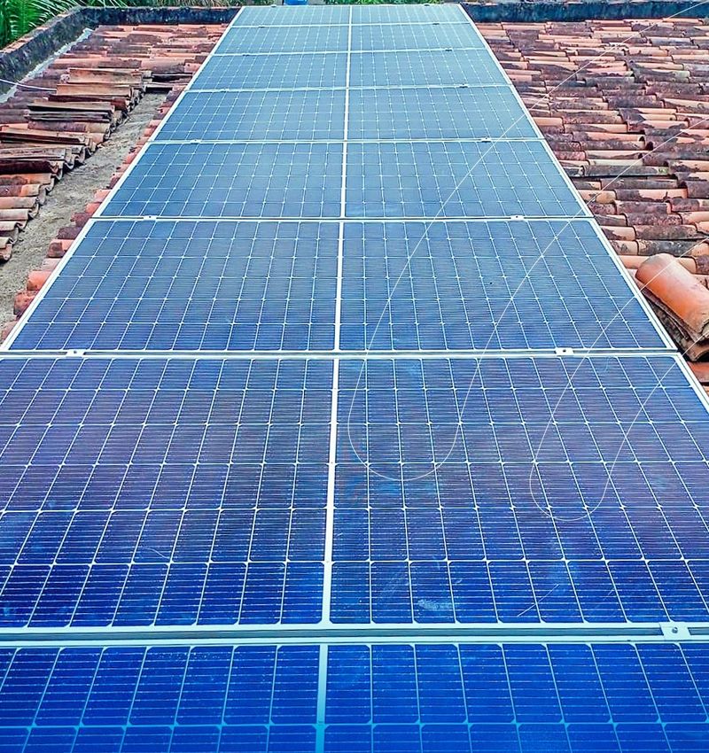 Fileira de módulos solares em telhado colonial